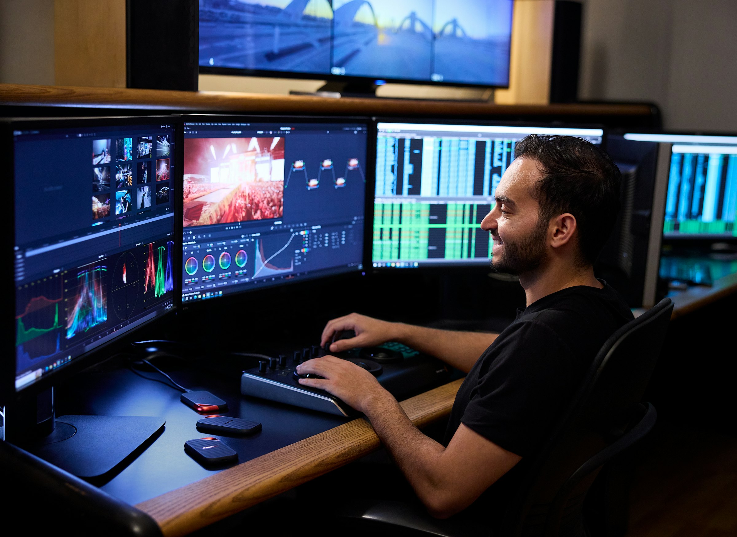 Editor cutting footage and building motion graphics across a multi-monitor color suite, Kabja Concepts enterprise video post-production in New York City