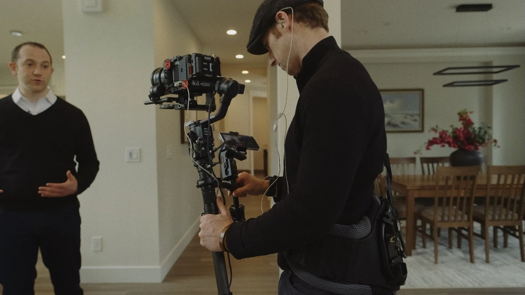 A Kabja cinematographer filming a real estate agent inside a luxury home on a stabilized gimbal camera rig.